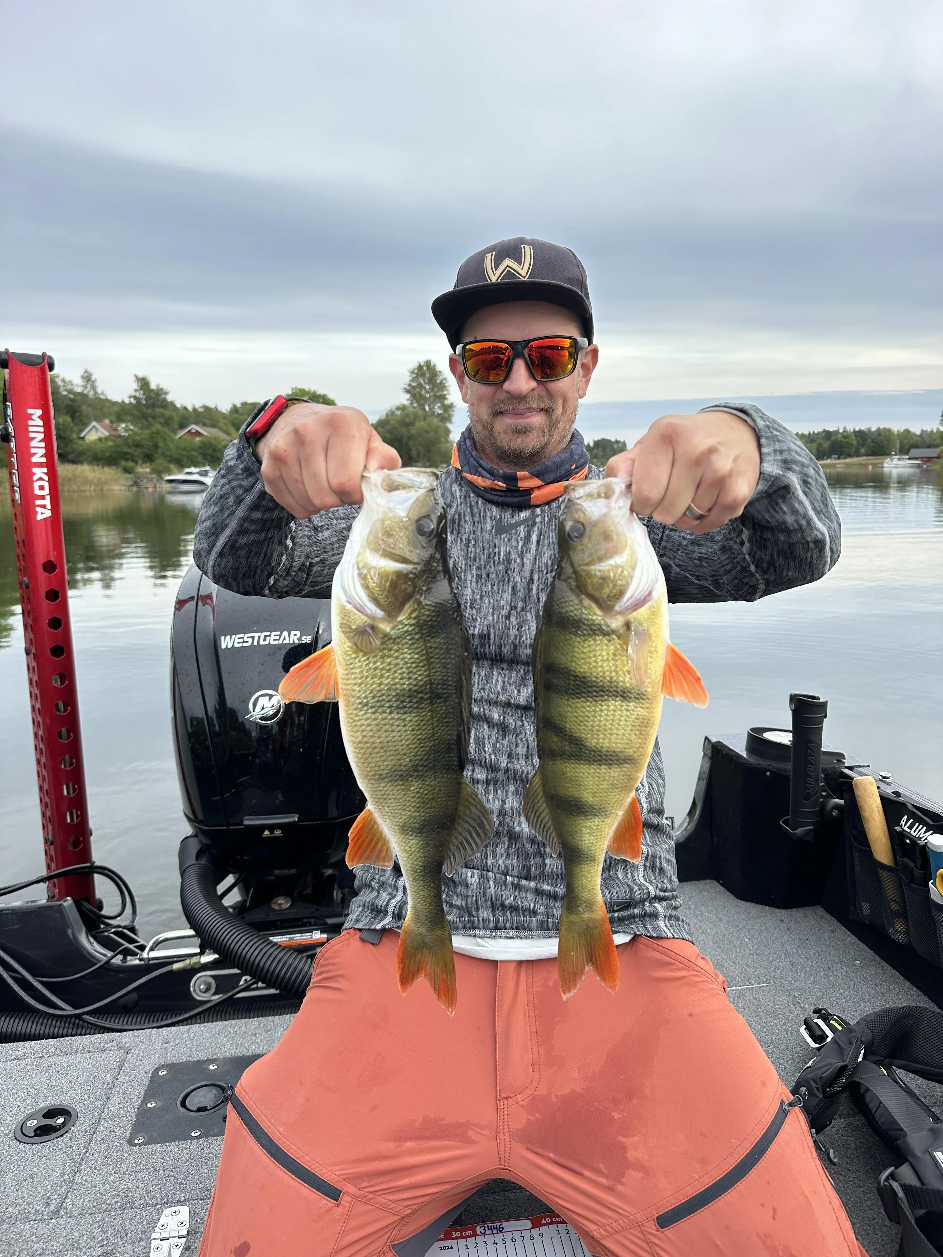 Miika med två abborrar på båten